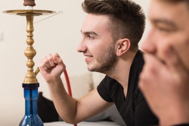 Twee broers of vrienden die samen videogames spelen terwijl ze ontspannen op een bank in de woonkamer