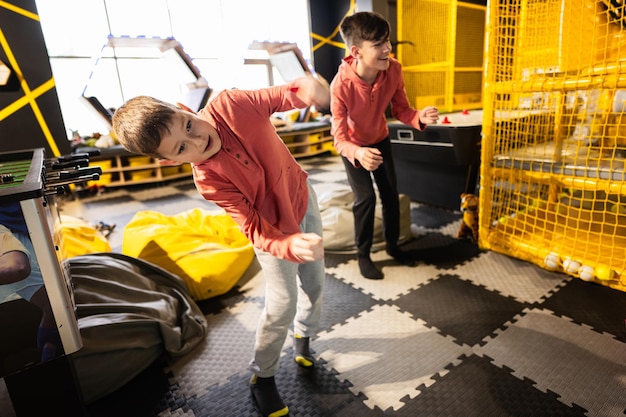 Twee broers rijden met een moderne videogameconsole per sensor in het speelcentrum voor kinderen