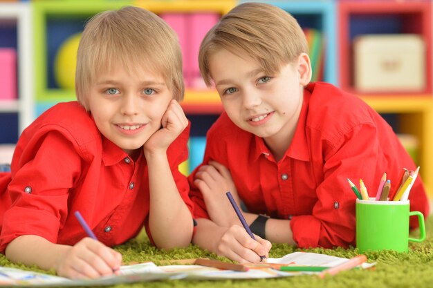 Twee broers tekenen met potloden.