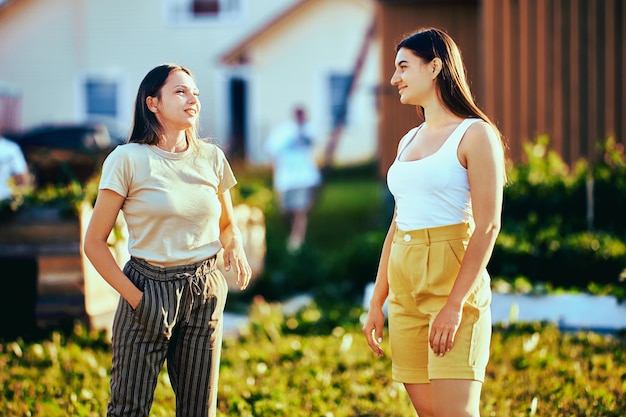 Twee buren ontmoetten elkaar op een dorpsstraat op een zomerdag. Europese vrouwen praten buiten.