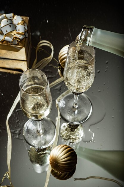 Foto twee champagne glazen die in glas nieuwjaarsachtergrond weerspiegelen