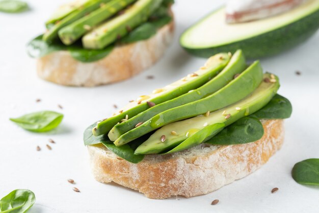 Twee ciabattatoost met gesneden avocado.