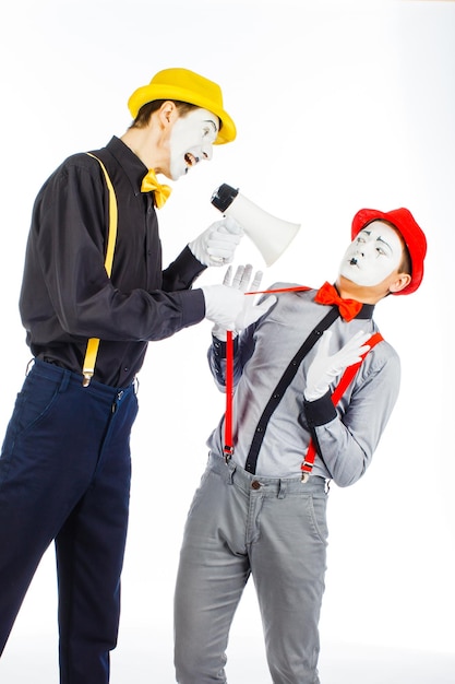 Twee clown MIME flitsende megafoon De uitdrukking van emoties op een witte achtergrond