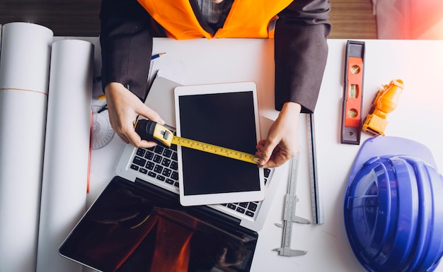 Twee collega's bespreken gegevens over werken en tablet-laptop met op architecturaal project op de bouwplaats aan de balie op kantoor