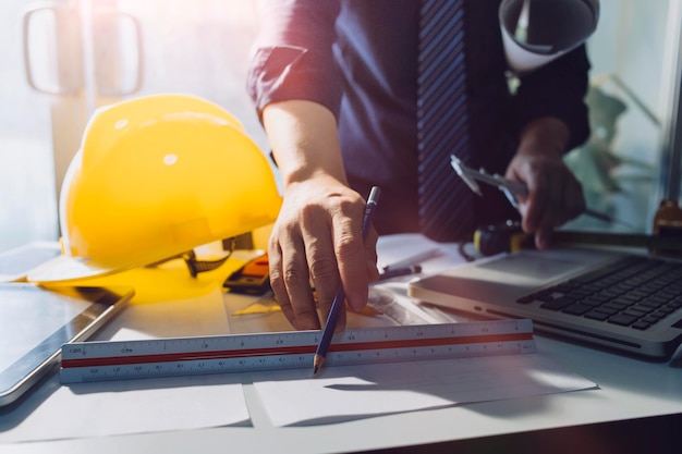 Twee collega's bespreken gegevens over werken en tablet-laptop met op architecturaal project op de bouwplaats aan de balie op kantoor