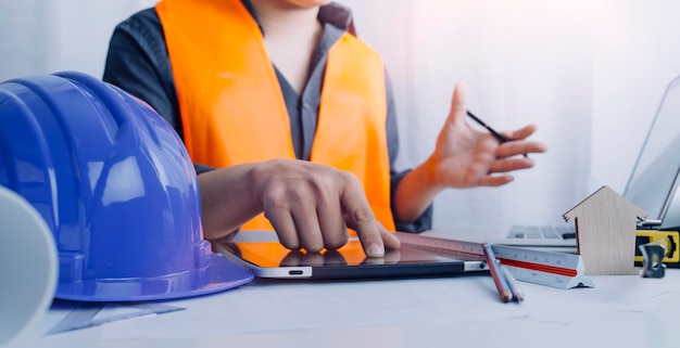 Twee collega's bespreken gegevens over werken en tablet-laptop met op architecturaal project op de bouwplaats aan de balie op kantoor