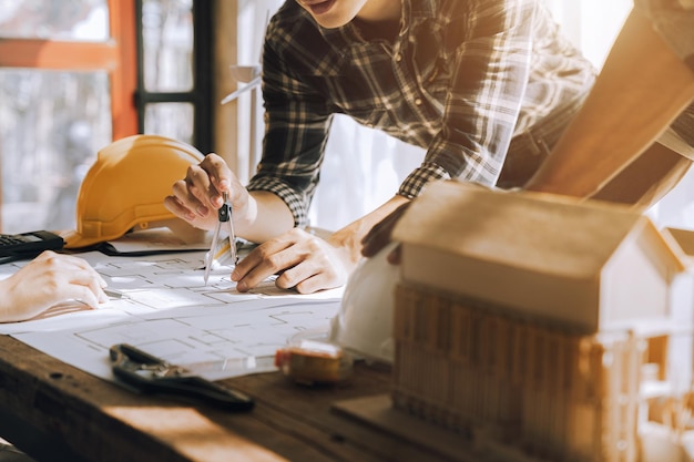 Twee collega's bespreken gegevens over werken en tablet-laptop met op architecturaal project op de bouwplaats aan de balie op kantoor