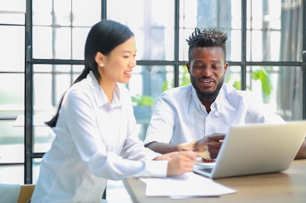 Twee collega's die documenten en andere werkmomenten op kantoor bespreken