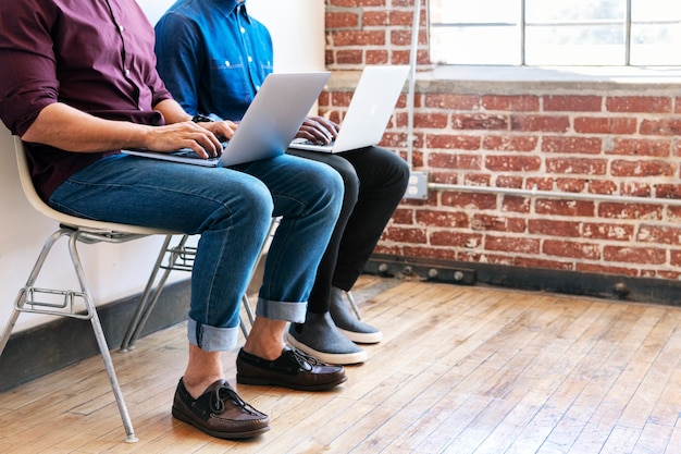 Twee collega's die samenwerken op hun laptop