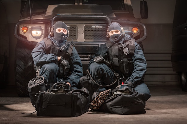 Twee commando's in uniform zitten in een hangar met een militaire vrachtwagen