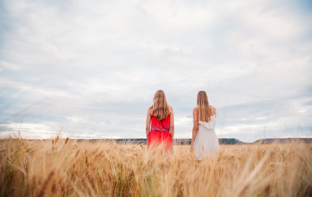 Twee dames in jurken op een tarweveld