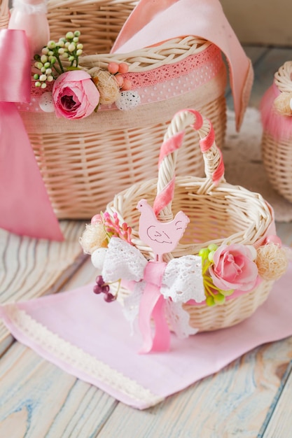 Twee decoratieve rieten mandjes in mooie lichtroze stijl met origineel decor van bloemen en veters Stijlvol bloemendecor op handgemaakte manden