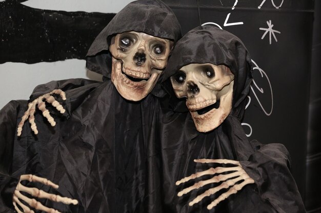 Foto twee decoratieve skeletten in zwarte regenjassen voor halloween