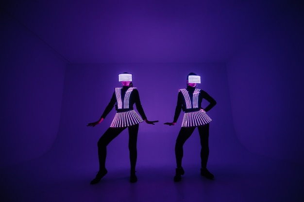Twee discodansers bewegen zich in UV-kostuums.