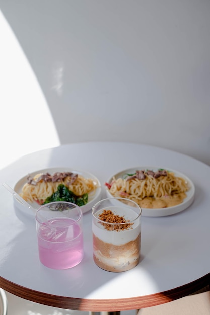 Twee drankjes met Rose Pasta Spaghetti geplaatst in een witte tafel