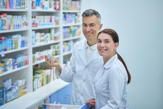 Foto twee drogisten in laboratoriumjassen bezig met inventarisatie in een drogisterij