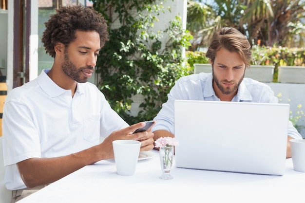 Twee drukke vrienden die samen koffie drinken