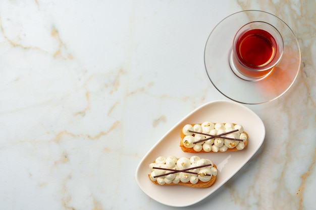 Twee eclairs met witte vla op witte plaat