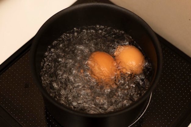 Twee eieren koken in een pot