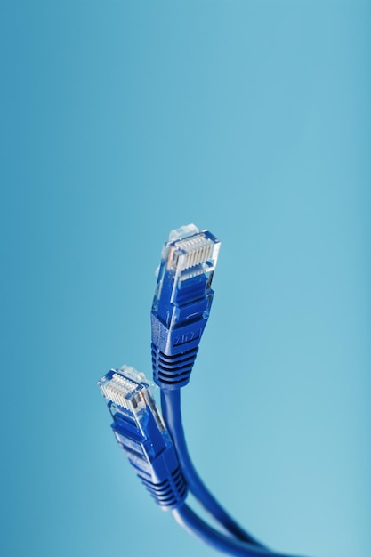 Twee Ethernet-kabelconnectoren Patchkabelsnoer close-up geïsoleerd op een blauwe achtergrond met vrije ruimte