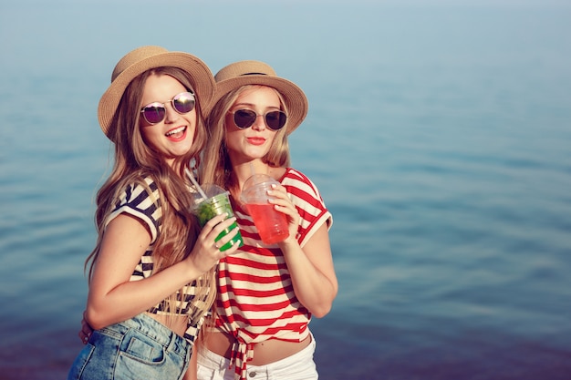 Twee Europese meisjes vermaken zich in de zomer op het strand