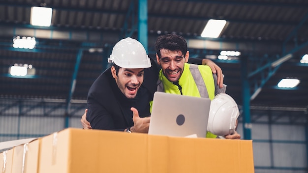 Twee fabrieksarbeiders vieren succes samen in de fabriek