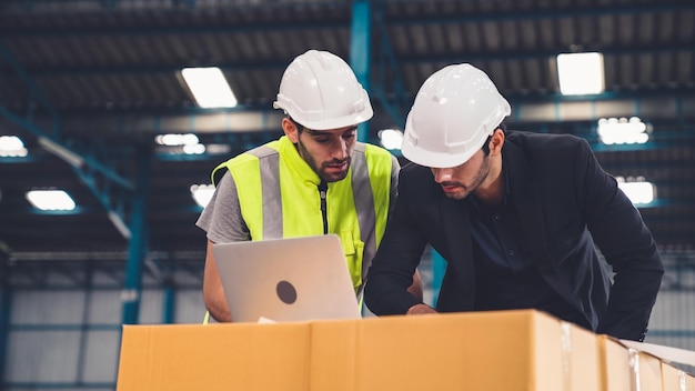 Twee fabrieksarbeiders werken en bespreken productieplan in de fabriek Industrie en engineering concept