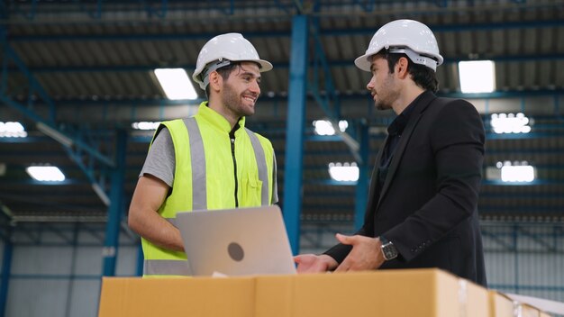 Twee fabrieksarbeiders werken en bespreken productieplan in de fabriek. Industrie en technisch concept.