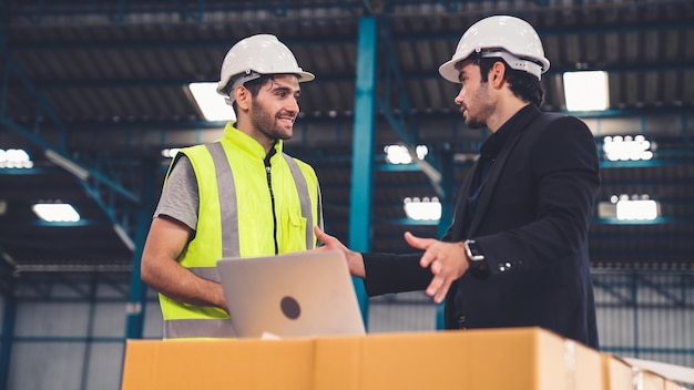 Twee fabrieksarbeiders werken en bespreken productieplan in de fabriek. industrie en technisch concept.