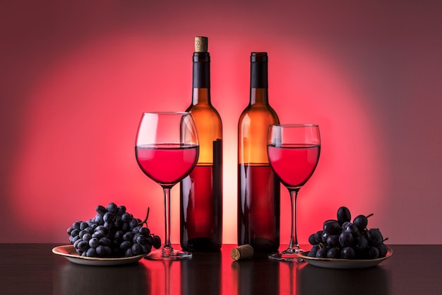 Twee fles wijn, wijnglas en druiven. Diverse soorten rode wijn.