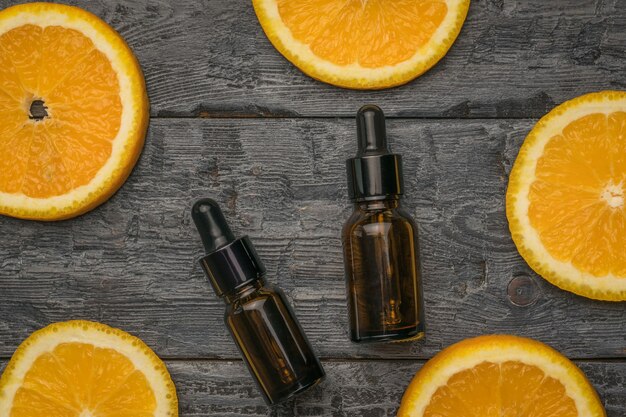 Twee flessen parfumwater en stukjes sinaasappel op een houten ondergrond. Natuurlijke cosmetica en geneesmiddelen.