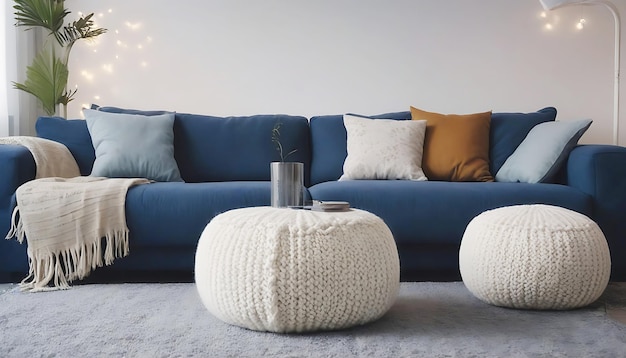 Twee gebreide poufs in de buurt van donkerblauwe hoekbank Scandinavisch huis interieurontwerp van moderne woonkamer