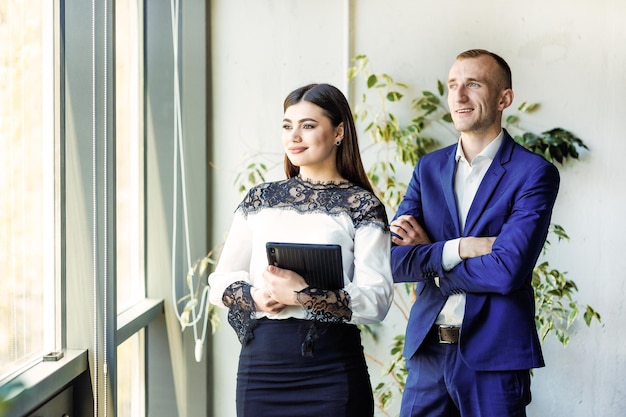 Twee geïnspireerde zakenpartners in een kantoor kijken naar de toekomst van hun zakelijk partnerschap