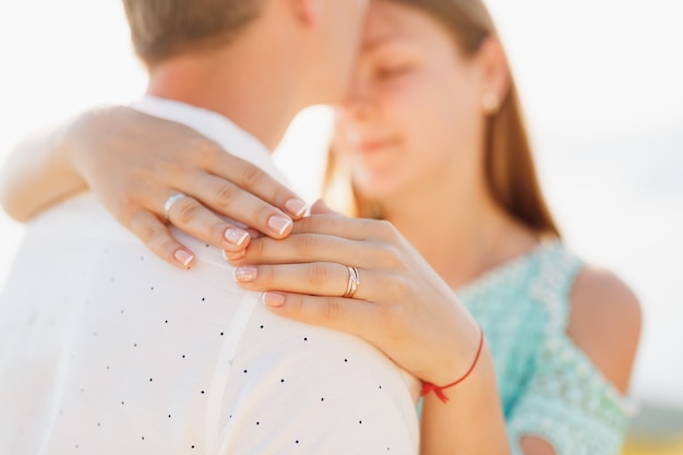 Twee geliefden, een vrouw knuffelt een man, haar handen op zijn schouders close-up