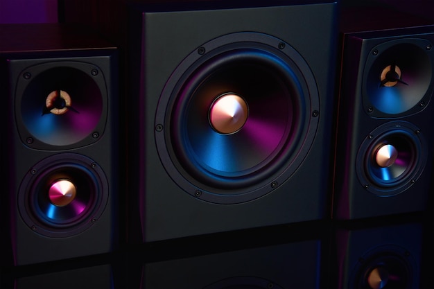 Twee geluidsluidsprekers en subwoofer op donkere achtergrond met neonlichten