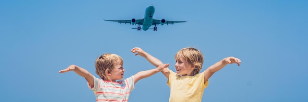 Twee gelukkige jongens op het strand en een landend vliegtuig dat reist met kinderen concept banner lang formaat