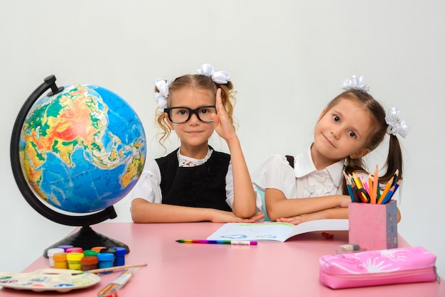 twee gelukkige kleine meisjes schilderen in de klas