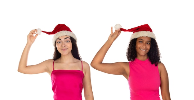 Twee gelukkige lachende meisjes in kerstmutsen kijken naar de camera