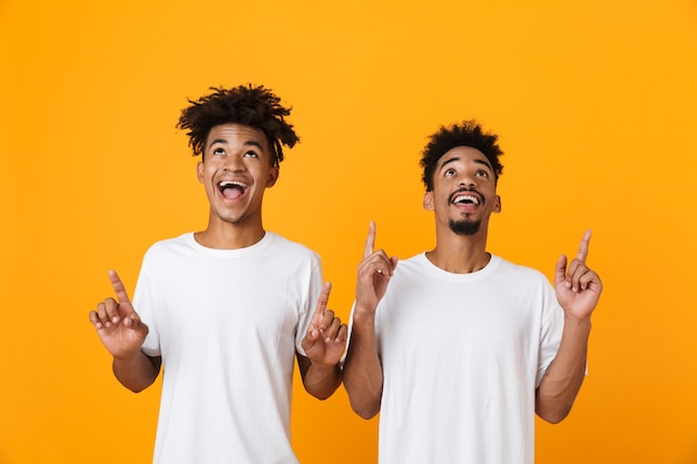 Twee gelukkige mannelijke vrienden in staande t-shirts