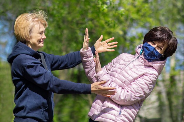 Foto twee gelukkige volwassen vrouwen dragen van beschermende maskers