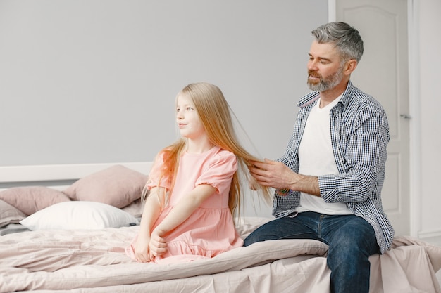 Twee generatie familie. Volwassen man die het haar van het meisje borstelt. Aanbiddelijk.