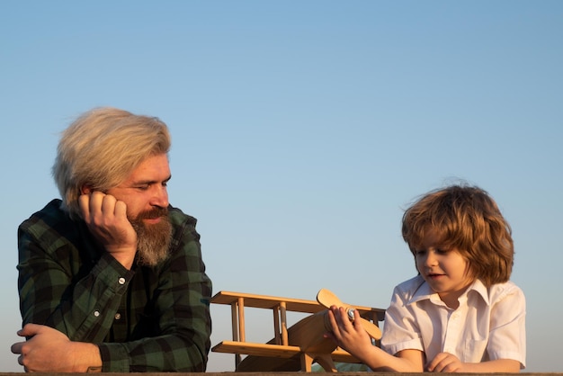 Twee generaties mannen, vader en zoon, hebben plezier en spelen met speelgoedvliegtuig Familierelatie met zoon Love daddy