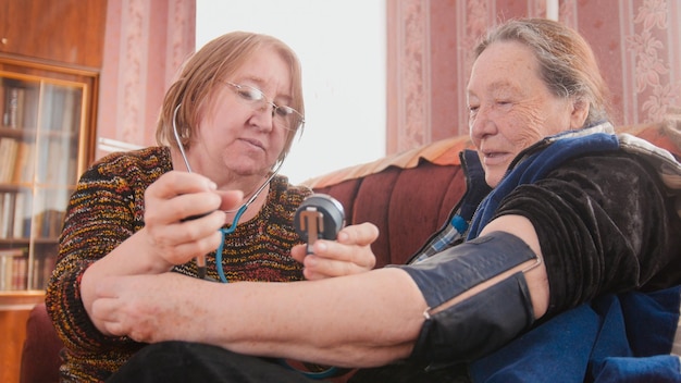 Foto twee gepensioneerden - gezondheidstoestand controleren met manometer - maatregelen druk, gepensioneerden gezondheidszorg, close-up