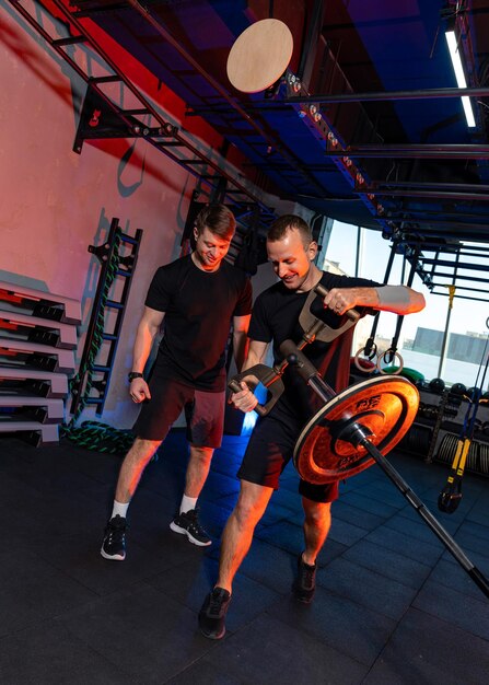 Twee gespierde, gematigde atleten werken hard Sterke mannen trainen hard in de sportschool