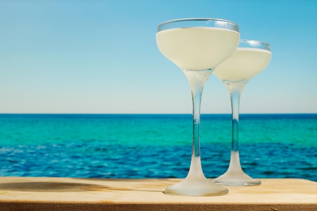 Twee Gimlet-cocktails op de zee van de tafelbar op de achtergrond