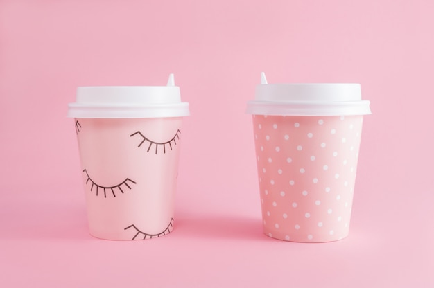 Twee glas koffie meeneem op roze pastelkleurachtergrond