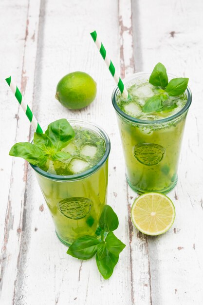 Twee glazen biologische limoenlimonade met basilicum