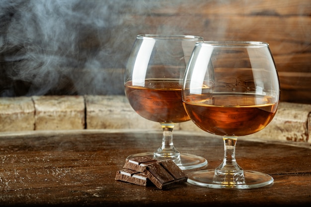 Twee glazen bourbon of whisky, of cognac en stukjes pure chocolade