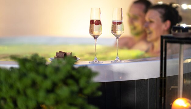 Twee glazen champagne en chocolade op een hot tub rand