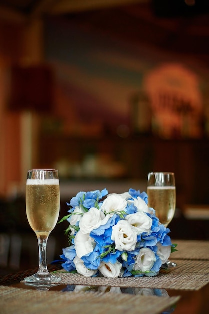Twee glazen champagne en een prachtig feestelijk bruidsboeket met bloemen